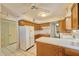 Well-lit kitchen with oak cabinets, white appliances, and classic tile creating a bright and inviting cooking space at 325 W Loma Ln, Phoenix, AZ 85021