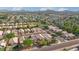 Aerial view of a neighborhood with many homes, trees, a golf course, and mountains in the distance at 3338 E Lavey Ln, Phoenix, AZ 85032