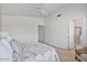 Bedroom with ceiling fan, plush bed and bathroom access at 3338 E Lavey Ln, Phoenix, AZ 85032