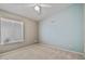 This bedroom features light and airy walls, a ceiling fan, and a sunlit window at 3338 E Lavey Ln, Phoenix, AZ 85032
