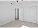 Bright bedroom featuring neutral carpet, ceiling fan, and double door closet at 3338 E Lavey Ln, Phoenix, AZ 85032
