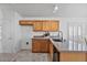Functional kitchen with wood cabinets, granite countertops, a sink, and white walls at 3338 E Lavey Ln, Phoenix, AZ 85032