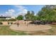Community playground featuring swings, picnic tables, mature shade trees, and a grassy area for outdoor activities at 3338 E Lavey Ln, Phoenix, AZ 85032