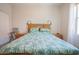 Bright bedroom featuring a wooden bed frame, palm tree bedding, and bedside tables with lamps at 34979 N 30Th Ave, Phoenix, AZ 85086