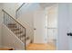 Hallway featuring stairs with metal railing, wood floors, and a view into the downstairs half bathroom at 34979 N 30Th Ave, Phoenix, AZ 85086