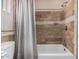 Bathroom with decorative tiled shower-tub combination with mosaic accents and shower curtain at 37334 N 17Th Ave, Phoenix, AZ 85086
