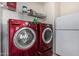 Laundry area with red washer and dryer units, overhead storage, and a white refrigerator at 37334 N 17Th Ave, Phoenix, AZ 85086