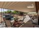 Covered patio featuring a dining area, comfortable seating, grill, and a hot tub, perfect for outdoor relaxation and entertainment at 37334 N 17Th Ave, Phoenix, AZ 85086