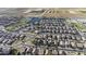 Aerial view of a residential community with houses, streets, and a nearby pond, showcasing the neighborhood layout at 37390 W Merced St, Maricopa, AZ 85138