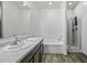 Bright, neutral bathroom boasts a tub and shower combo, plus sleek vanity and fixtures at 37390 W Merced St, Maricopa, AZ 85138