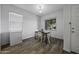 Bright dining area with modern light fixture, wood-style flooring, and a window view at 37390 W Merced St, Maricopa, AZ 85138