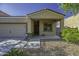 Welcoming home exterior with a stone accent, spacious covered porch, and desert-friendly landscaping at 37390 W Merced St, Maricopa, AZ 85138