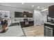 Modern kitchen featuring sleek countertops, dark cabinets, and stainless steel appliances at 37390 W Merced St, Maricopa, AZ 85138