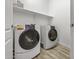 Well-lit laundry room features modern washer and dryer, plus ample shelf space for storage at 37390 W Merced St, Maricopa, AZ 85138