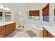 Bright bathroom featuring a marble shower, soaking tub, dual sinks, and warm wooden cabinetry at 4229 E Nightingale Ln, Gilbert, AZ 85298