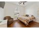 Cozy bedroom with a ceiling fan, wood flooring, and chair at 4229 E Nightingale Ln, Gilbert, AZ 85298