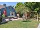 Spacious backyard with a seating area, grassy lawn, mature trees, and a fun playset, perfect for outdoor enjoyment at 530 W Willetta St, Phoenix, AZ 85003