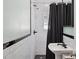 Bright bathroom with a stylish black and white tiled shower and pedestal sink with sleek fixtures at 530 W Willetta St, Phoenix, AZ 85003