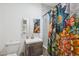 Well-lit bathroom with a modern sink, toilet, and shower featuring colorful curtain at 530 W Willetta St, Phoenix, AZ 85003