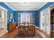 Bright dining room featuring hardwood floors, blue walls, natural lighting, and a classic wooden table at 530 W Willetta St, Phoenix, AZ 85003
