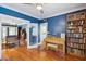 Blue living room with piano, bookshelf and hardwood floors, featuring a doorway with french doors at 530 W Willetta St, Phoenix, AZ 85003