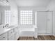 Bright, spacious bathroom showcasing glass block window, soaking tub, vanity and separate glass-enclosed shower at 6368 W Firebird Dr, Glendale, AZ 85308