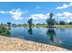 Beautiful lakeside view with lush greenery and palm trees, enhanced by a stone-lined edge at 6368 W Firebird Dr, Glendale, AZ 85308