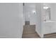 Hallway showcases a bright bathroom sink and multiple rooms, featuring wood-look flooring and white walls at 6368 W Firebird Dr, Glendale, AZ 85308