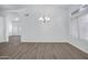 Spacious living area featuring wood-look flooring, neutral walls, and elegant lighting fixtures at 6368 W Firebird Dr, Glendale, AZ 85308