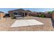 Spacious backyard featuring gravel landscaping, a concrete pad, a hot tub, and lush greenery, perfect for outdoor living at 7620 W Pioneer St, Phoenix, AZ 85043