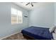 Serene bedroom featuring neutral carpet, blue walls, and a window that offers peaceful views and natural light at 7620 W Pioneer St, Phoenix, AZ 85043