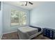 Bright bedroom featuring neutral carpet, blue walls, and a window that fills the room with natural light at 7620 W Pioneer St, Phoenix, AZ 85043