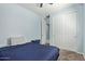 Comfortable bedroom featuring neutral carpet, blue walls, and a convenient closet with sliding doors at 7620 W Pioneer St, Phoenix, AZ 85043