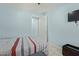 Bright bedroom with a ceiling fan, TV and an open doorway at 7620 W Pioneer St, Phoenix, AZ 85043