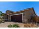 Single-story home with a two-car garage, stone accents, and low-maintenance landscaping at 7620 W Pioneer St, Phoenix, AZ 85043