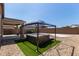 Outdoor hot tub under a gazebo, set on a small green artificial turf pad in the backyard at 7620 W Pioneer St, Phoenix, AZ 85043
