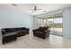 Spacious living room with tile flooring, blue walls, and a sliding door to the backyard at 7620 W Pioneer St, Phoenix, AZ 85043
