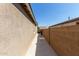 Well-maintained side yard with a concrete pathway and privacy wall, offering a clean and functional outdoor space at 7620 W Pioneer St, Phoenix, AZ 85043