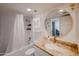 Bright bathroom with granite counters, a round mirror, and a shower-tub combination at 7970 E Camelback Rd # 101, Scottsdale, AZ 85251
