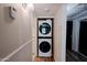 Convenient laundry area with a stacked washer and dryer unit, optimizing space and functionality at 7970 E Camelback Rd # 101, Scottsdale, AZ 85251