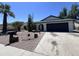 Charming home featuring desert landscaping, including cacti and a decorative wagon wheel, with a wide driveway at 8133 W Mclellan Rd, Glendale, AZ 85303