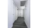 Clean, modern hallway with gray flooring and white doors, illuminated by recessed lighting at 8133 W Mclellan Rd, Glendale, AZ 85303