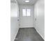 Bright hallway features gray tile flooring, white walls, and a window providing natural light at 8133 W Mclellan Rd, Glendale, AZ 85303