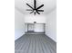 Spacious living room featuring modern gray floors, white walls, and a stylish ceiling fan at 8133 W Mclellan Rd, Glendale, AZ 85303