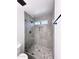 Modern shower with glass enclosure, geometric tile and decorative stone floor at 8133 W Mclellan Rd, Glendale, AZ 85303