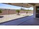 The backyard features neutral rock landscaping, mature trees, and covered patio at 8230 E Navarro Ave, Mesa, AZ 85209