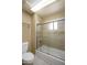 Bathroom showcasing tiled shower with glass door, grab bars, updated hardware, and a white toilet at 8230 E Navarro Ave, Mesa, AZ 85209