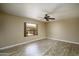 Bedroom featuring a ceiling fan, neutral color walls, wood-look floors, and a large window with outdoor views at 8230 E Navarro Ave, Mesa, AZ 85209