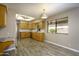 Kitchen with wood cabinets, stainless steel appliances, tile backsplash, granite counters, and wood-style floors at 8230 E Navarro Ave, Mesa, AZ 85209