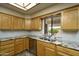 Well-lit kitchen with granite countertops, stainless steel appliances, wood cabinetry, and wood-style flooring at 8230 E Navarro Ave, Mesa, AZ 85209